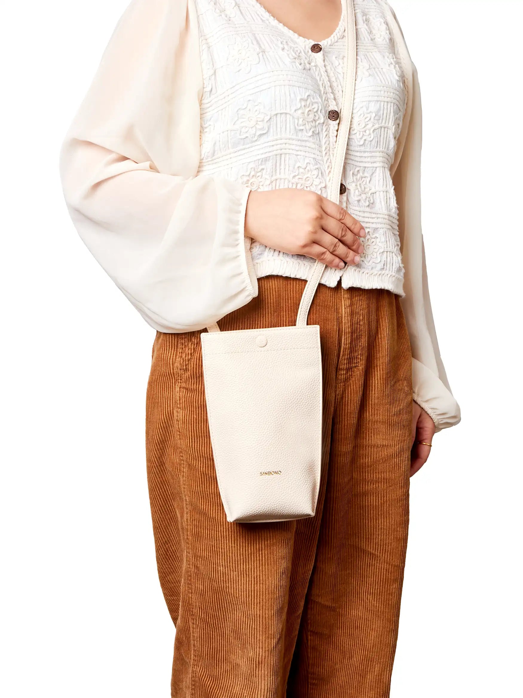 Sharla Crossbody Wallet Phone Bag in Ivory Vegan Leather - Model Holding Front View